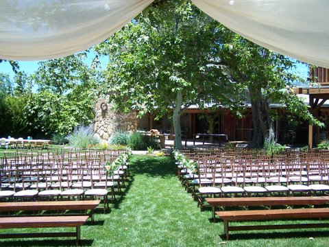 view of seating on lawn from under fabric awning